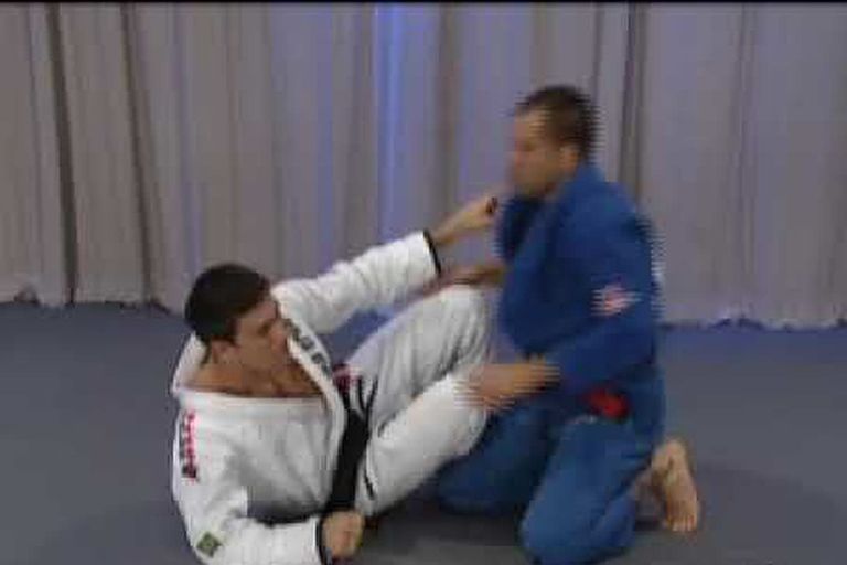 Demian Maia defending his guard against a passing opponent in the gi
