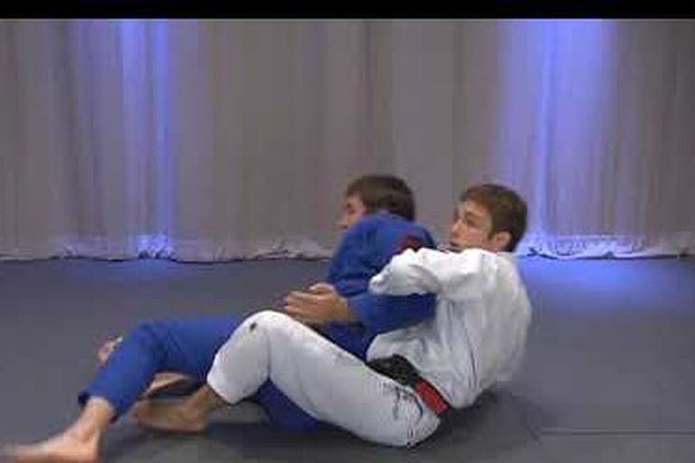 Rolling back attack demonstrated in Brazilian Jiu Jitsu