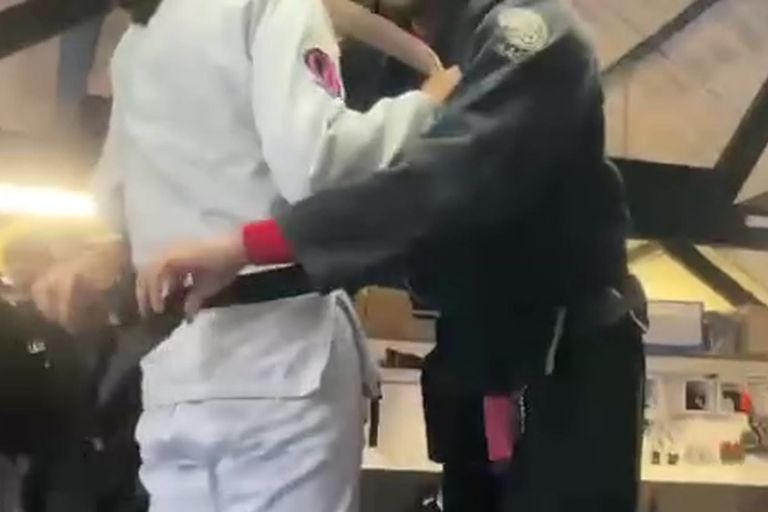 Seonghae Wilson being tied into her Brazilian jiu-jitsu black belt by her instructor at her promotion ceremony